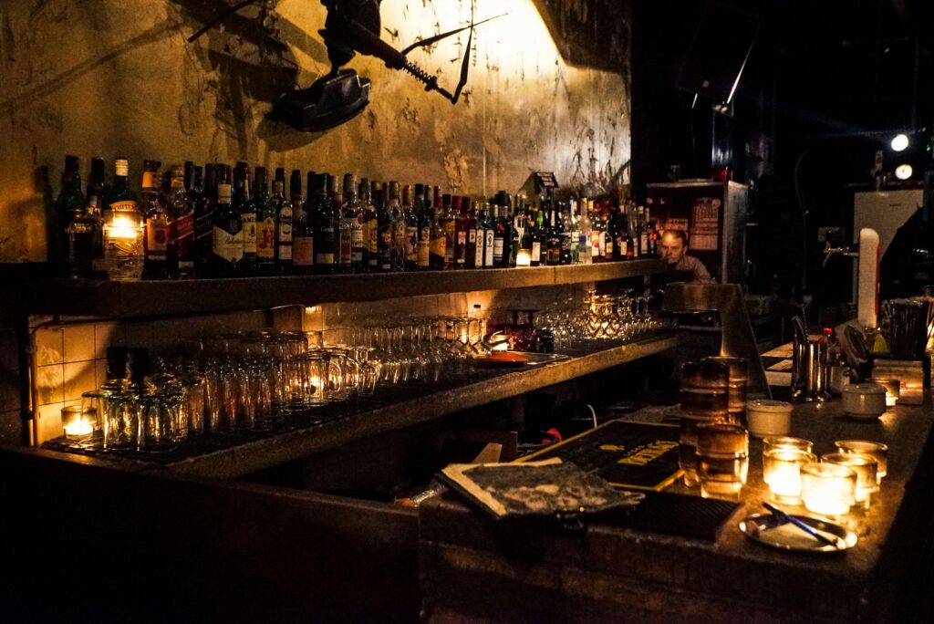 A cozy bar setup with whiskey bottles and warm candlelight, creating a relaxed mood.